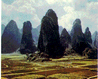 Color photograph of a group of rock towers in the Guangxi Province of Southern China.