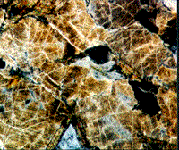Color photomicrograph of "toasting" in quartz crystals from the Manson structure.